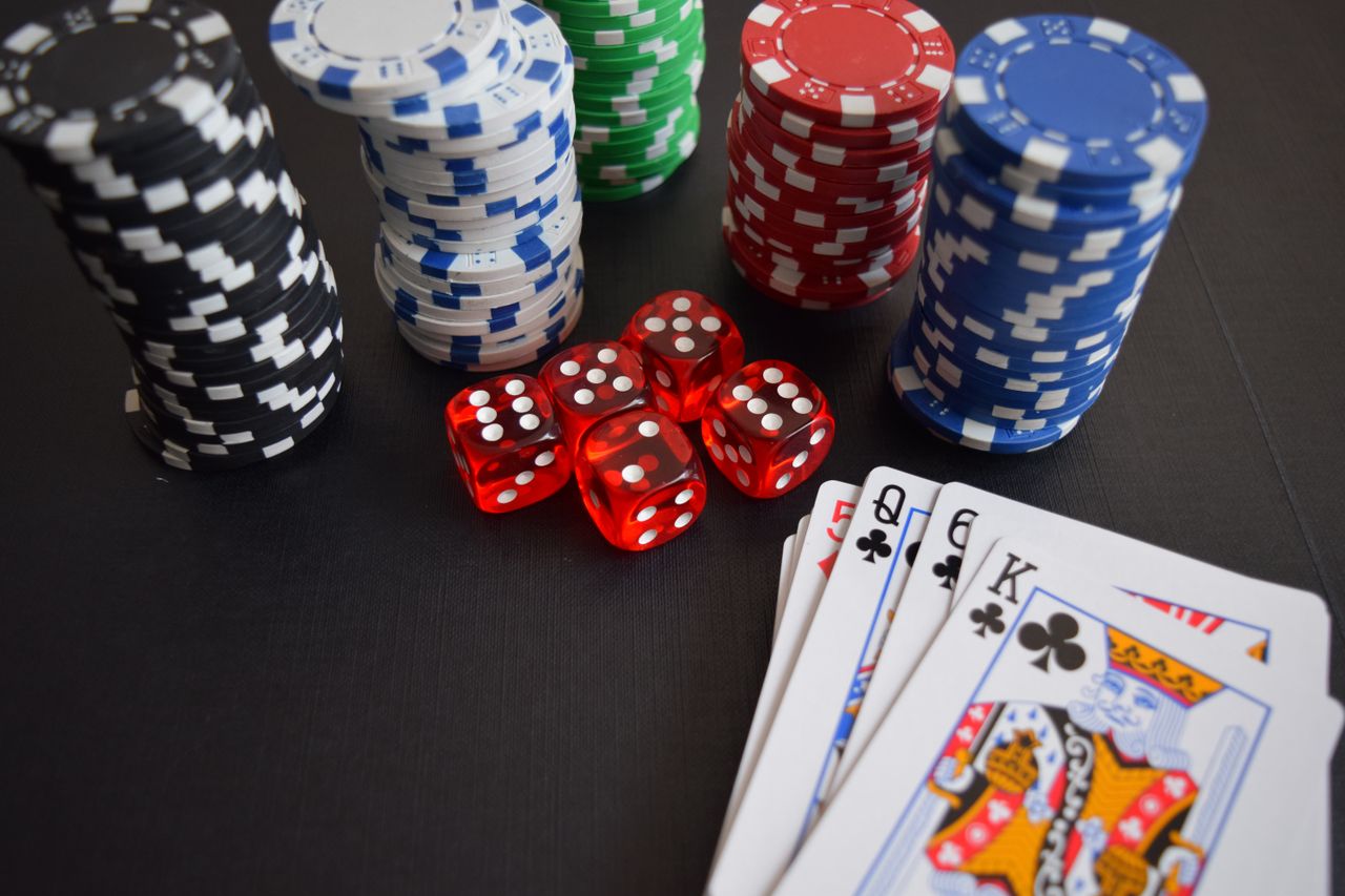 hero-img-02 A vibrant display of casino chips, dice, and playing cards set on a table, embodying chance and excitement.