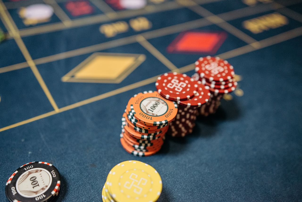 services-03 Stacked casino chips on a vibrant roulette table, symbolizing chance and gaming excitement.