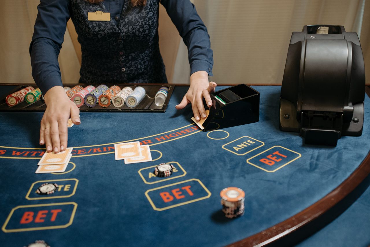 gallery-2 Casino dealer organizing cards and chips on a gaming table during a game.