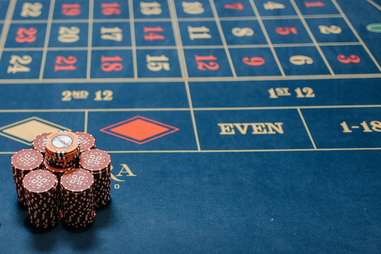 ours-journey Detailed image of a roulette table with poker chips stacked, showcasing casino gaming.